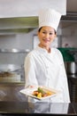 Confident female chef holding cooked food in kitchen Royalty Free Stock Photo