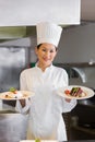 Confident female chef holding cooked food in kitchen Royalty Free Stock Photo