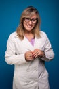 Confident female doctor dressed in beige coat, wearing glasses and smiling. Positive person Royalty Free Stock Photo