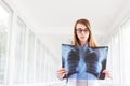 Confident female doctor examining accurately a rib cage x-ray. Royalty Free Stock Photo