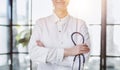 Confident female doctor posing in her office and smiling at camera, health care and prevention concept Royalty Free Stock Photo