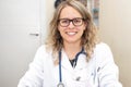 Confident female doctor posing smiling in her office. Royalty Free Stock Photo