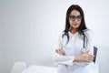 Confident female doctor standing arms crossed in office. Royalty Free Stock Photo