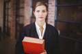 Confident female lawyer with book standing in office Royalty Free Stock Photo