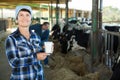 Confident female milker with milk on dairy farm Royalty Free Stock Photo