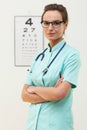 Confident female optometrist standing with arms crossed