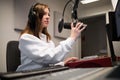 Radio Jockey Adjusting Microphone While Wearing Headphones In St