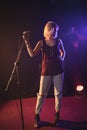 Confident female singer holding microphone in illuminated nightclub Royalty Free Stock Photo