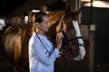 Confident female vet stroking horse Royalty Free Stock Photo