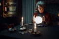 Confident fortune teller doing predictions with illuminated crystal ball