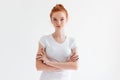 Confident ginger woman in t-shirt posing with crossed arms