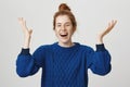 Confident girl finally did it and won. Portrait of celebrating excited attractive woman with ginger hair in blue sweater