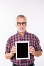 Confident gray aged man with glasses showing a screen of tablet