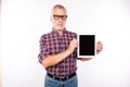 Confident gray aged man with glasses showing a screen of tablet