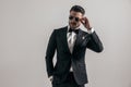 Confident groom in elegant tuxedo with hand in pocket adjusting sunglasses Royalty Free Stock Photo