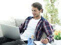 Confident guy working with laptop at home. Royalty Free Stock Photo