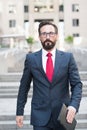 Confident handsome businessman walking down city stairs