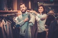 Confident handsome man with beard choosing a jacket in a suit shop. Royalty Free Stock Photo