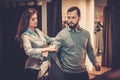 Confident handsome man with beard choosing a jacket in a suit shop. Royalty Free Stock Photo