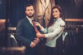 Confident handsome man with beard choosing a tie in a suit shop. Royalty Free Stock Photo