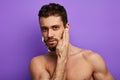 Confident handsome man touching his face skin during morning shaving Royalty Free Stock Photo