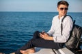 Confident handsome yacht owner settles his business issues while sailing in sea