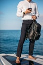 Confident handsome yacht owner settles his business issues while sailing in sea