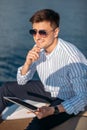 Confident handsome yacht owner settles his business issues while sailing in sea