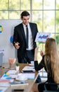 Confident handsome young adult caucasian businessman leader presenting work to multiracial colleagues in the meeting at the Royalty Free Stock Photo