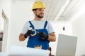 Confident handyman, electrician smiling aside holding duct tape for installing new electrical socket outlet in apartment Royalty Free Stock Photo