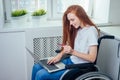 Confident happy redhaired ginger businesswoman student in wheelchair working at office