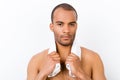 Confident harsh young mulatto nude man is standing on the pure w Royalty Free Stock Photo