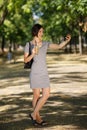 Beautiful girl taking a selfie. Woman with a smoothie on a blurred park background. Taking pictures concept. Copy space. Royalty Free Stock Photo