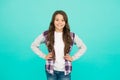 Confident in her style. happy small girl turquoise background. cheerful schoolgirl has long curly hair. child wear