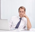 Confident in himself and his company. a handsome and confident young businessman sitting at his office desk. Royalty Free Stock Photo