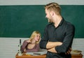 Confident in his knowledge. Handsome man standing hands crossed in classroom with teacher. Male student with examiner at