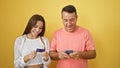 Confident hispanic father and his daughter enjoying financial confidence, smiling and texting payment using smartphone and credit