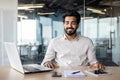 Confident indian businessman in office, working on laptop at modern desk Royalty Free Stock Photo