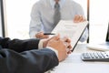 Confident insurance agent broker man holding document and present pointing showing an insurance policy contract form to client