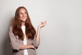 Confident joyful businesswoman showing empty palm hand against white studio wall banner background Royalty Free Stock Photo