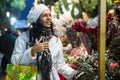 Confident Latin American woman chooses a composition of flowers