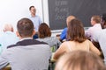 Confident lecturer talking to mixed age students