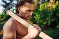 Confident look. Close up portrait of woodsman with axe in hand. Handsome shirtless man with muscular body type is in the Royalty Free Stock Photo