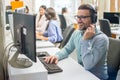 Confident male customer support operator with headset working in call center Royalty Free Stock Photo