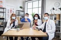 Multiracial doctors in protective masks showing thumbs up at office meeting