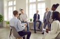 Confident male leader talking with multiracial group of workers in office Royalty Free Stock Photo