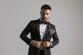 Confident male model buttoning black tuxedo