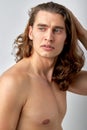 confident male model is touching long hair, head, enjoy having healthy face skin Royalty Free Stock Photo