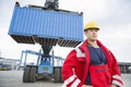 Confident male worker standing in front of freight vehicle at shipyard