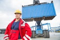 Confident male worker standing in front of freight vehicle at shipyard